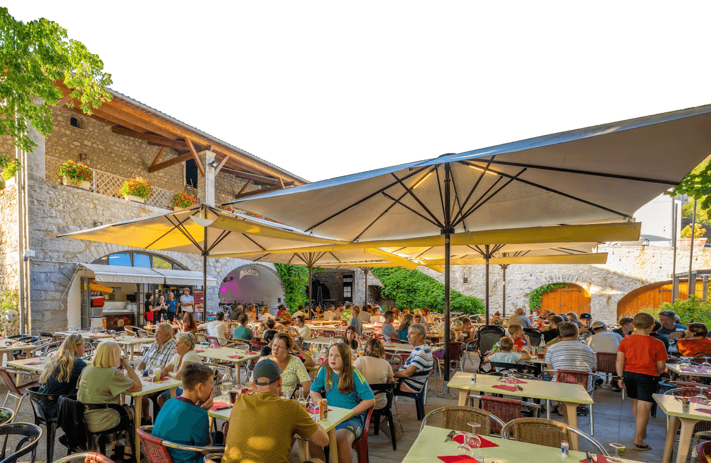 Le restaurant Terrasse ombragée du restaurant du Domaine Arleblanc, tables dressées sous les parasols